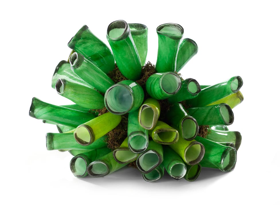 Green glass sculpture. Resembles a pile of tubes with open mouths.