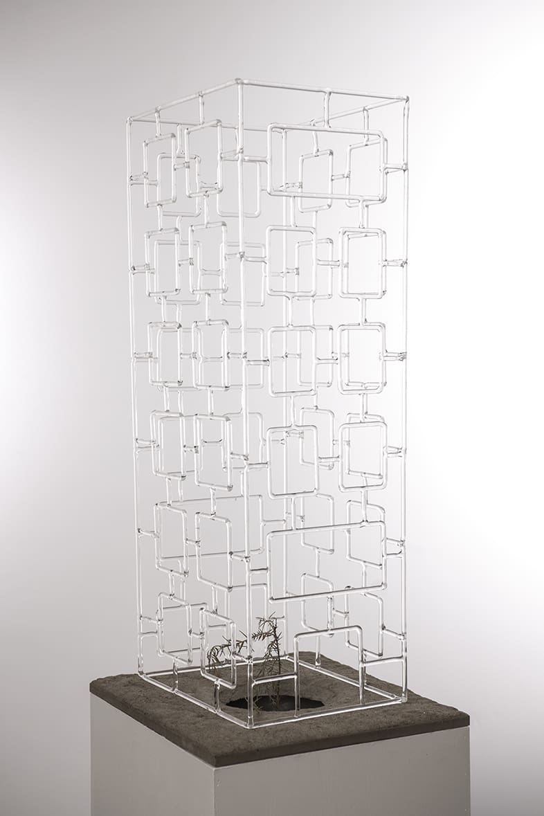 Abstract metal sculpture. the sculpture is a rectangular prism made up of rods bend at ninety degree angles.