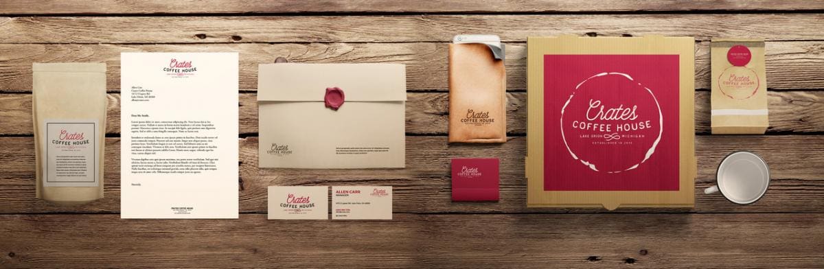 Photo of various products and stationary associated with Crate's Coffee House brand identity. The color scheme is tan, dark red and white. Pictured on a wooden table.