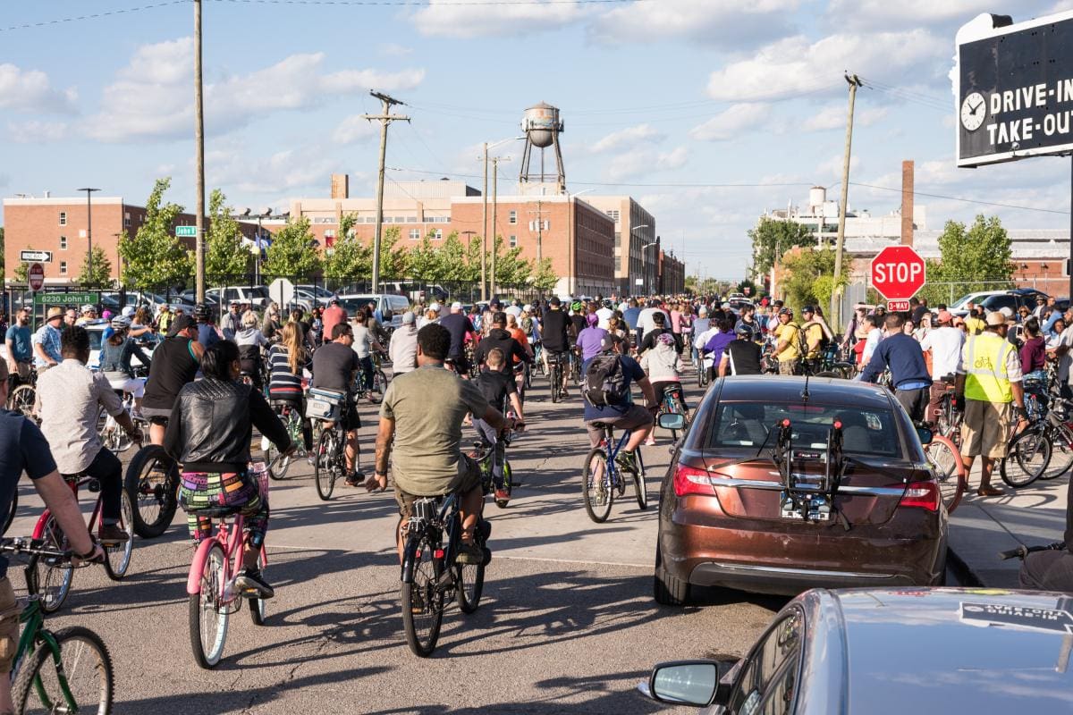 Photo of a crowd of bikers biking down the road of downtown Detroit