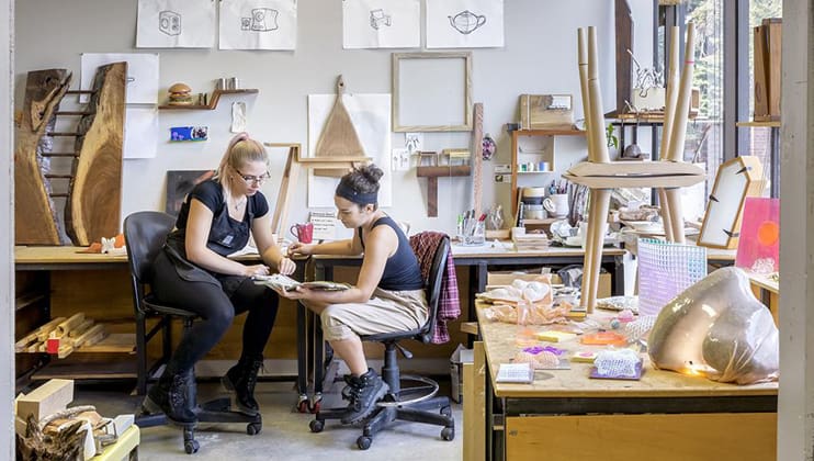 Two students working on a project together in the studio