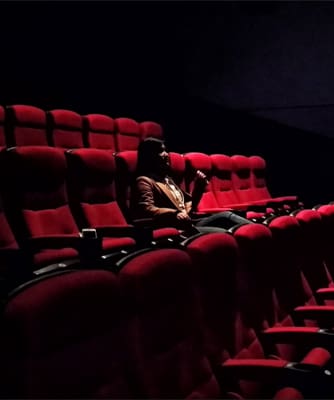 A person sitting in a dark movie theater