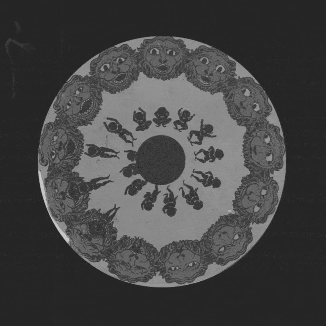 Screenshot of a motion sequence about cults. Photo depicts a black and white mandala against a black background. Around the perimeter are drawn lion heads with different facial expressions. There is a central black dot. Around the perimeter of the smaller dot are drawn figures in different stages of jumping.