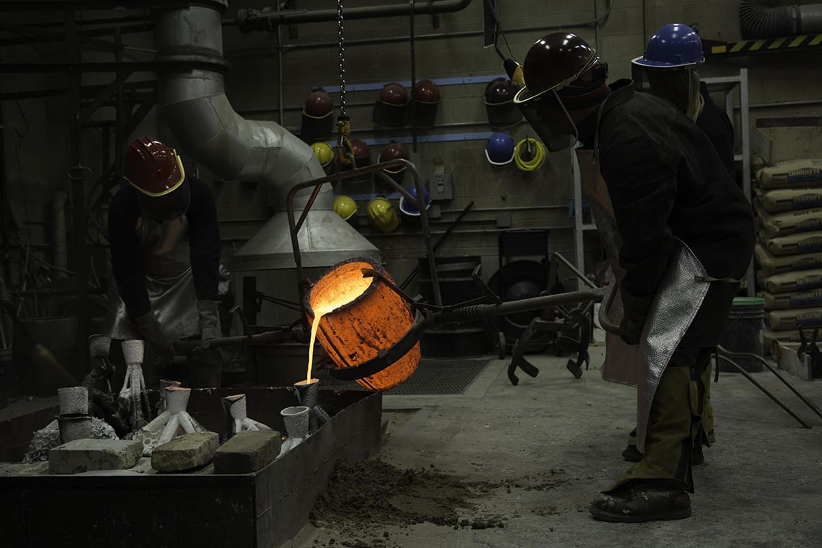 Students taking part in an iron pour in the foundry