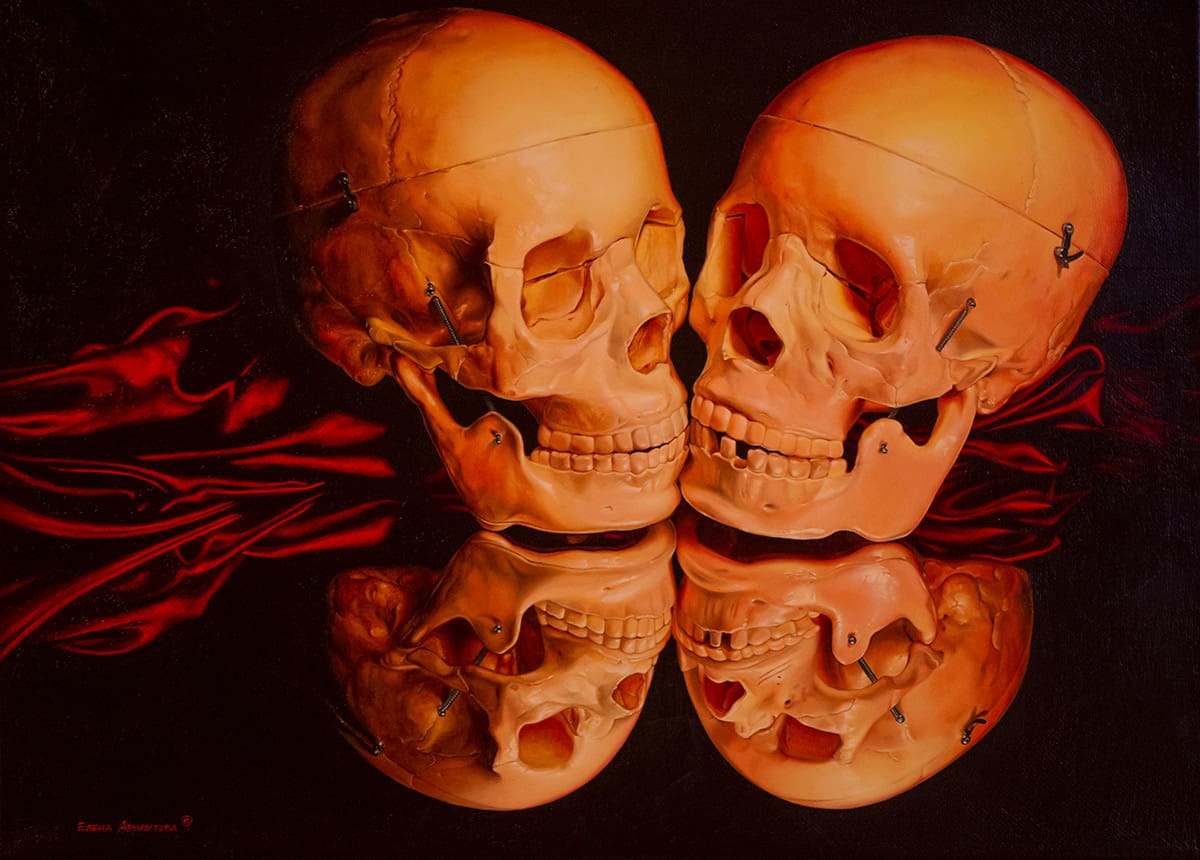 two skulls facing each other on top of a red cloth